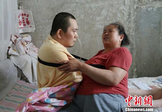 身體日漸衰老的梁青蘭每次幫兒子翻身、坐立，全身的衣物都要濕透一次?！∩忻鱾b 攝