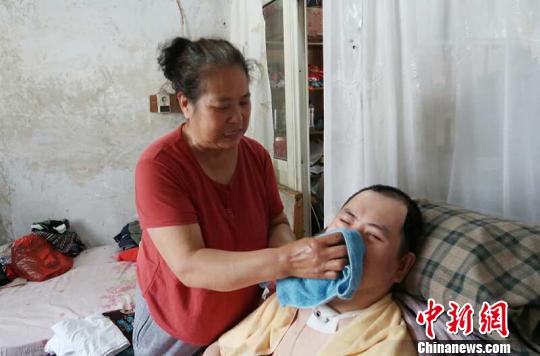 每次喂完食物后，梁青蘭都要仔細地幫兒子清理干凈?！∩忻鱾b 攝