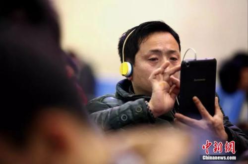 資料圖：候車室內(nèi)，玩手機(jī)的&ldquo;低頭族&rdquo;隨處可見(jiàn)。刷微博、聊微信、玩游戲、看電影，高科技將大多旅客變?yōu)槭謾C(jī)&ldquo;低頭族&rdquo;。<a target='_blank' ><p  align=