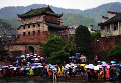游客在鳳凰古城北門城樓下冒雨等待乘船游覽