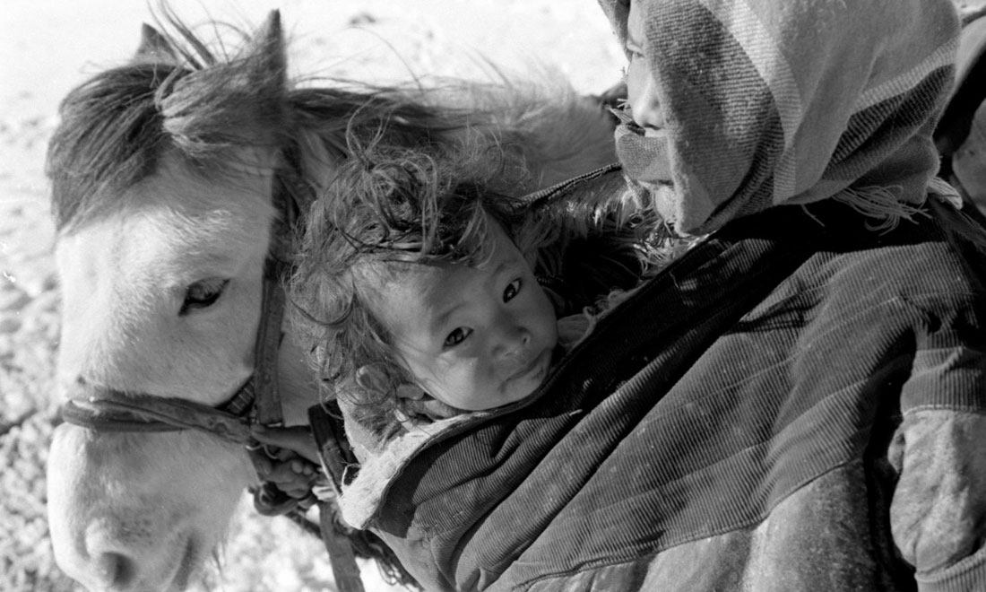 1990年3月，西藏當(dāng)雄縣納木湖鄉(xiāng)三村女牧民斯卓不畏嚴(yán)寒，懷抱幼子，準(zhǔn)備到遠(yuǎn)處放牧。新華社記者覺果攝