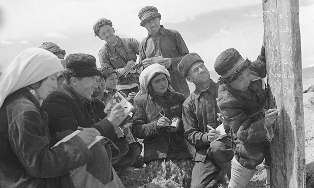 1960年6月，新疆慕士塔格峰下，大人們在小學(xué)生幫助下學(xué)習(xí)文化。新華社記者武純展攝